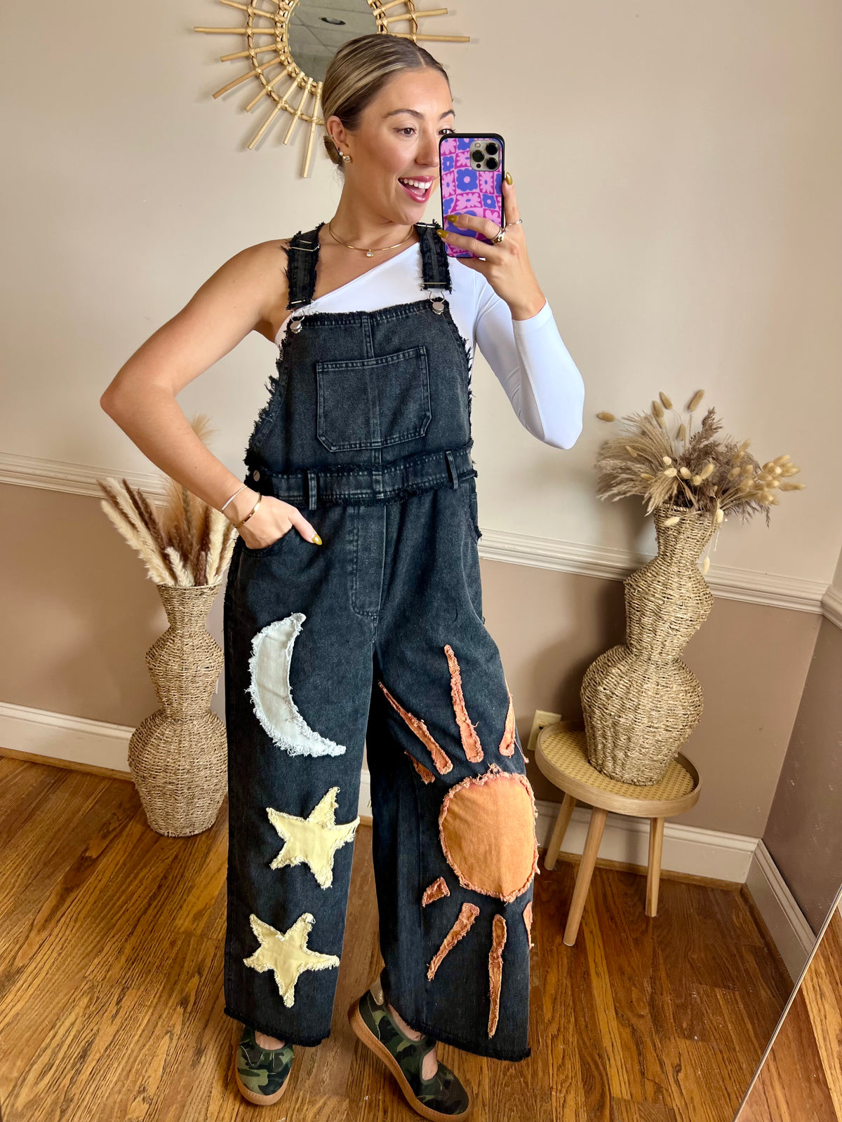 Black boho overalls with whimsical sun, moon and star patchwork details, styled as a casual women's boutique outfit