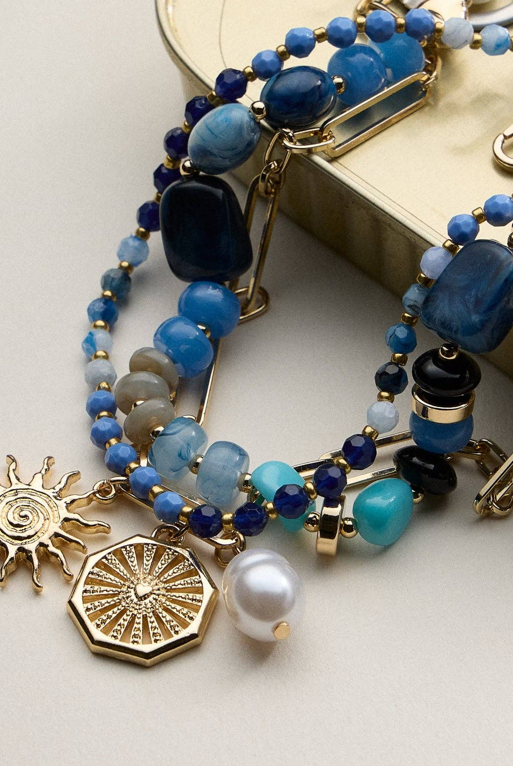 Multistrand beaded bracelet with gold charms on a light background, blue and gold necklace, accessory, summer necklace, gifts, necklaces