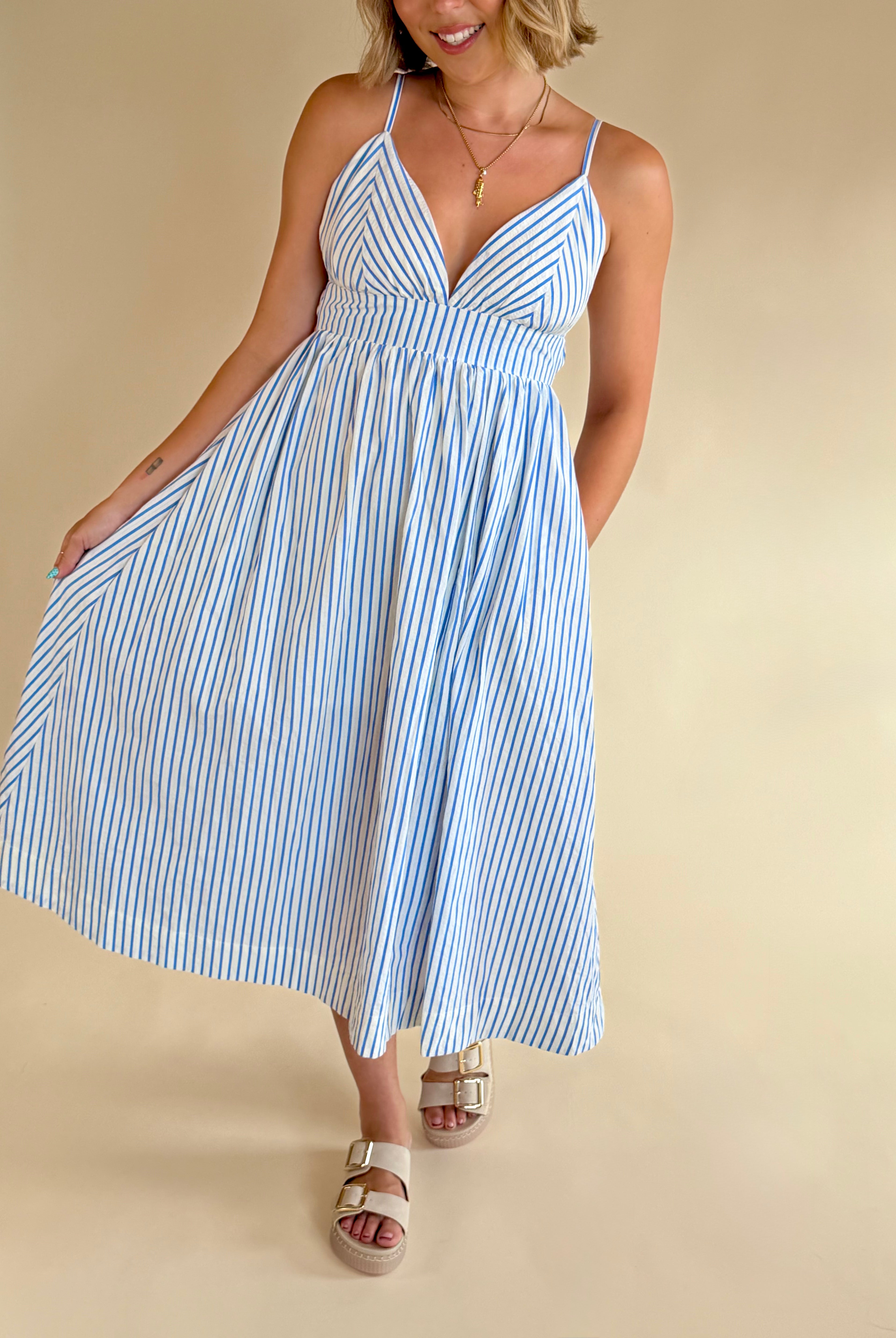Woman wearing a blue and white striped dress on a beige background, blue and white stripe maxi, summer dress, elevated style, elegant dress, blue and white, pinstripe