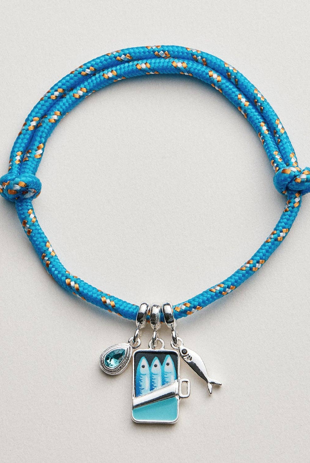 Blue braided bracelet with charms on a light gray background, bracelet, accessories, gifts, rope bracelet, sardine charm