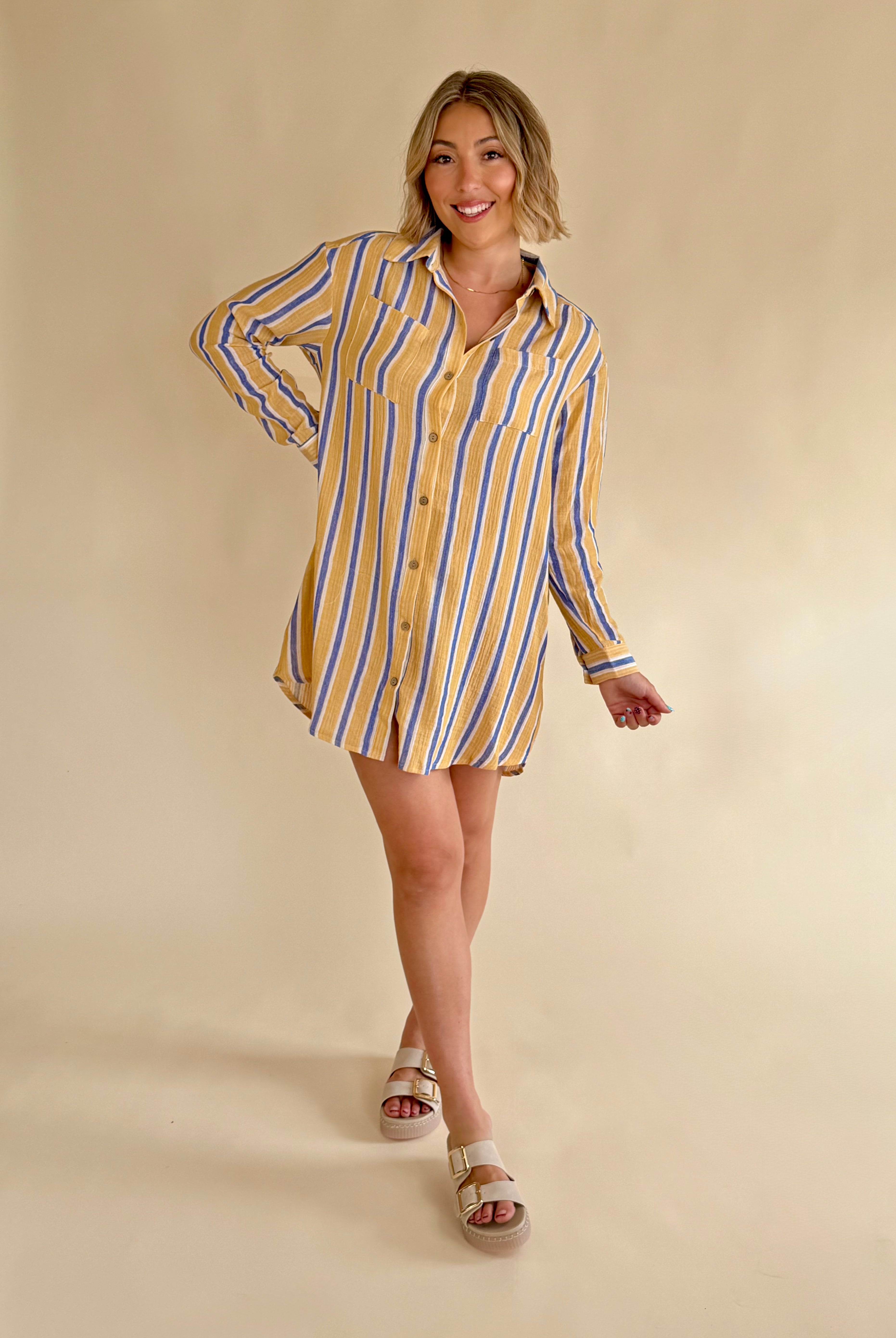 Woman wearing a yellow and blue striped shirt dress on a beige background, summer style, blue and yellow stripe, gauze dress, long sleeve dress, summer style, stripe print dress