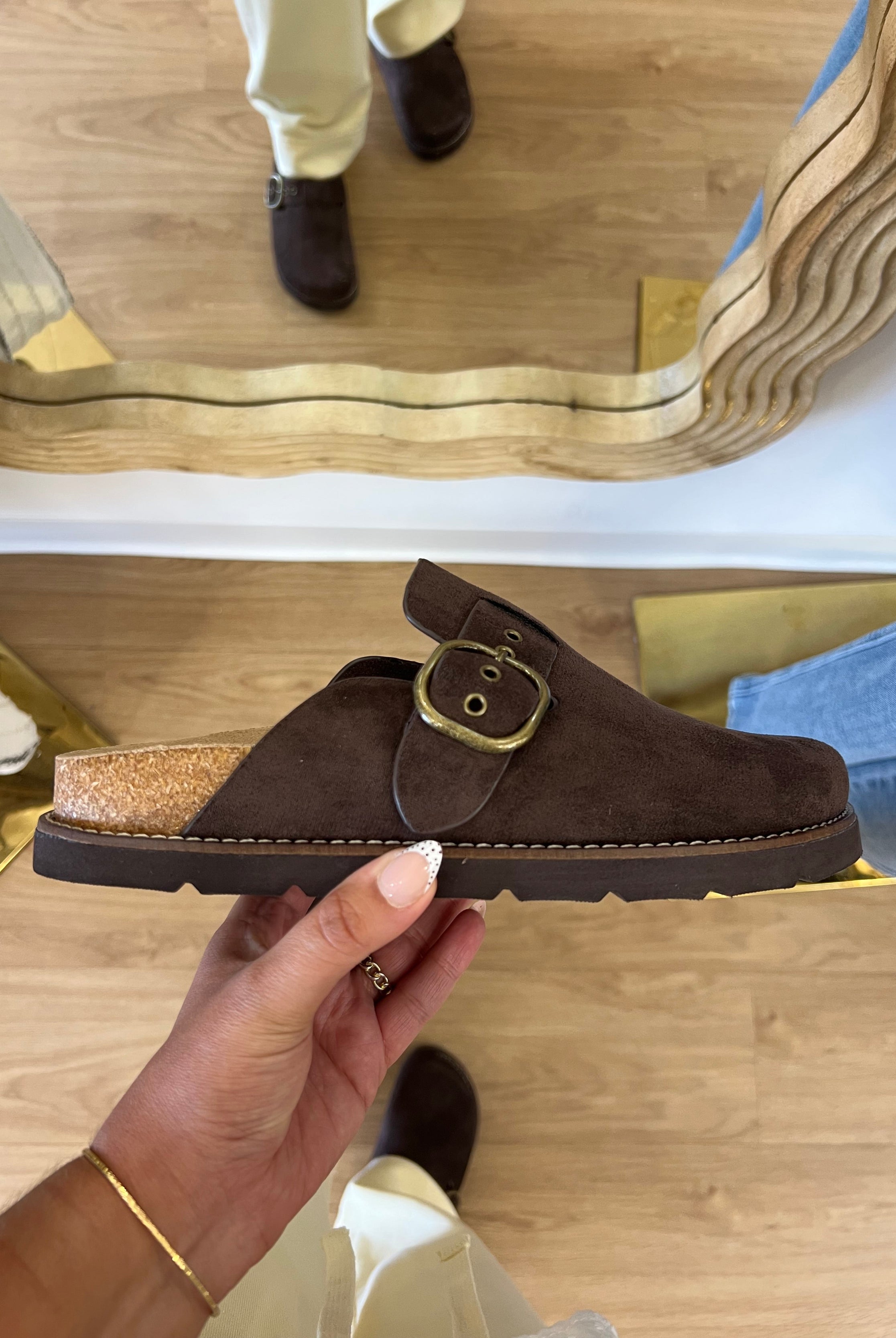 Corky’s Distracted women’s chocolate brown faux-suede clogs with a statement buckle, contoured footbed, and cushioned sole.