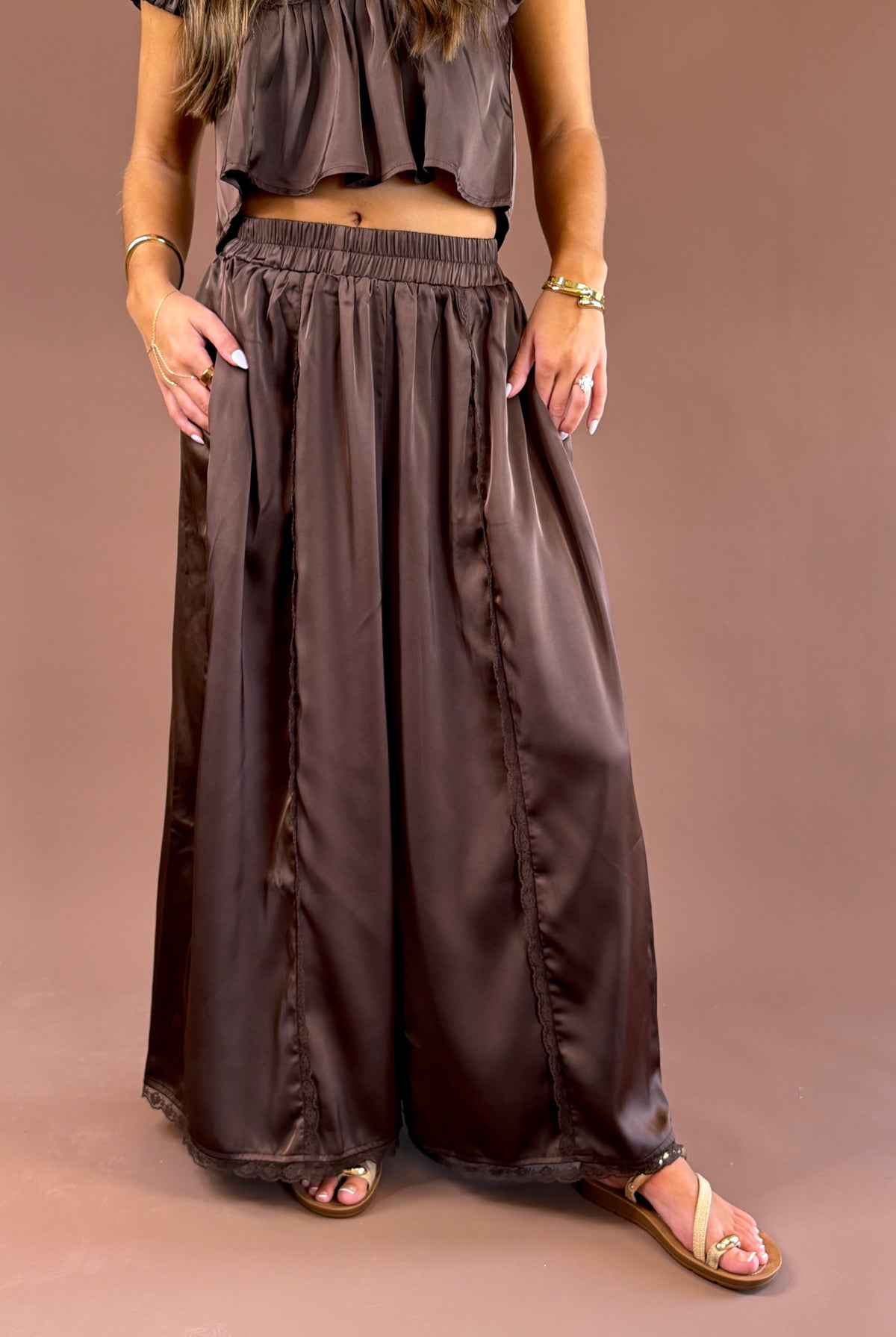 Espresso Hour women’s dark brown satin pull-on pants with a comfortable elastic waistband, subtle lace detailing, and flowy wide legs
