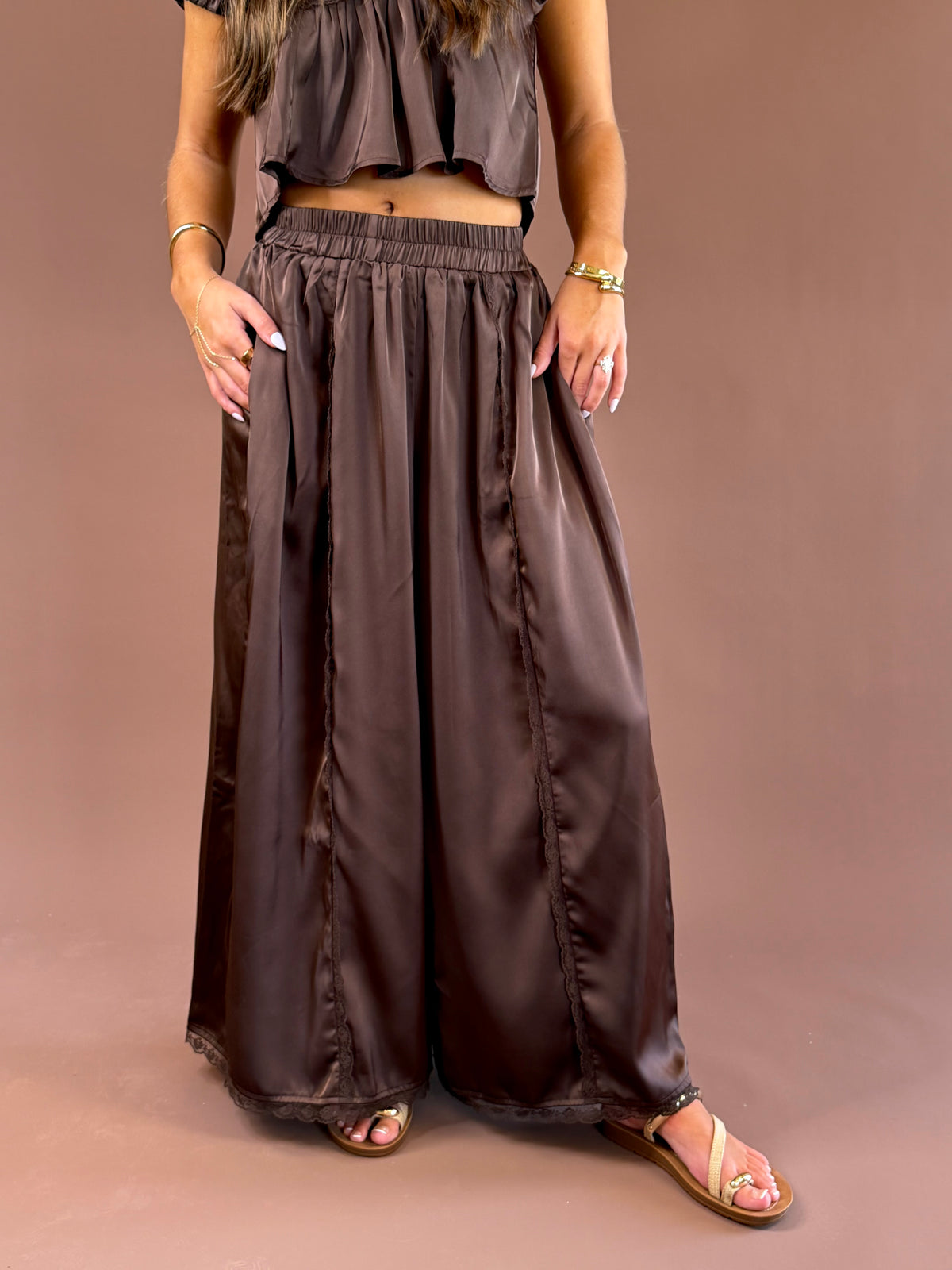 Espresso Hour women’s dark brown satin pull-on pants with a comfortable elastic waistband, subtle lace detailing, and flowy wide legs
