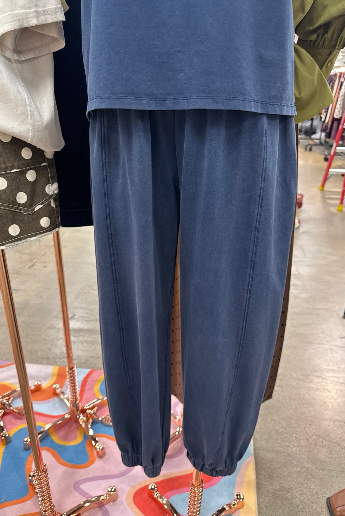 Indigo blue high-waisted jogger pants with an elastic waistband, relaxed fit, and cuffed ankles.