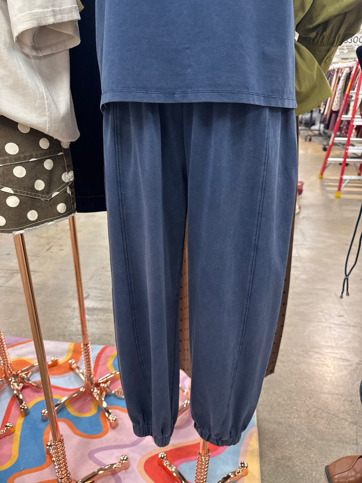 Indigo blue high-waisted jogger pants with an elastic waistband, relaxed fit, and cuffed ankles.