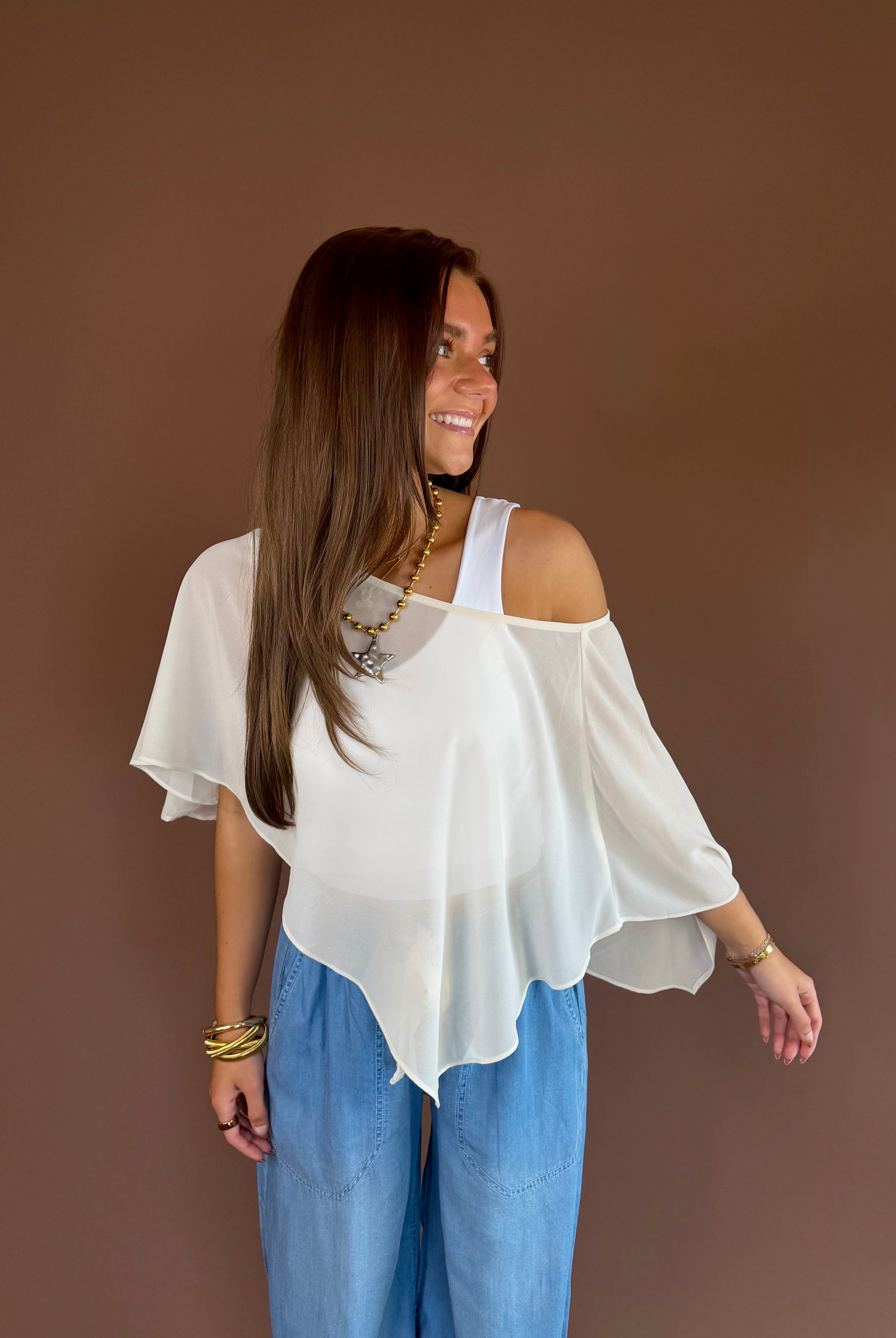 Cream ivory sheer poncho top with a cropped flowy silhouette and adjustable slouch neckline.