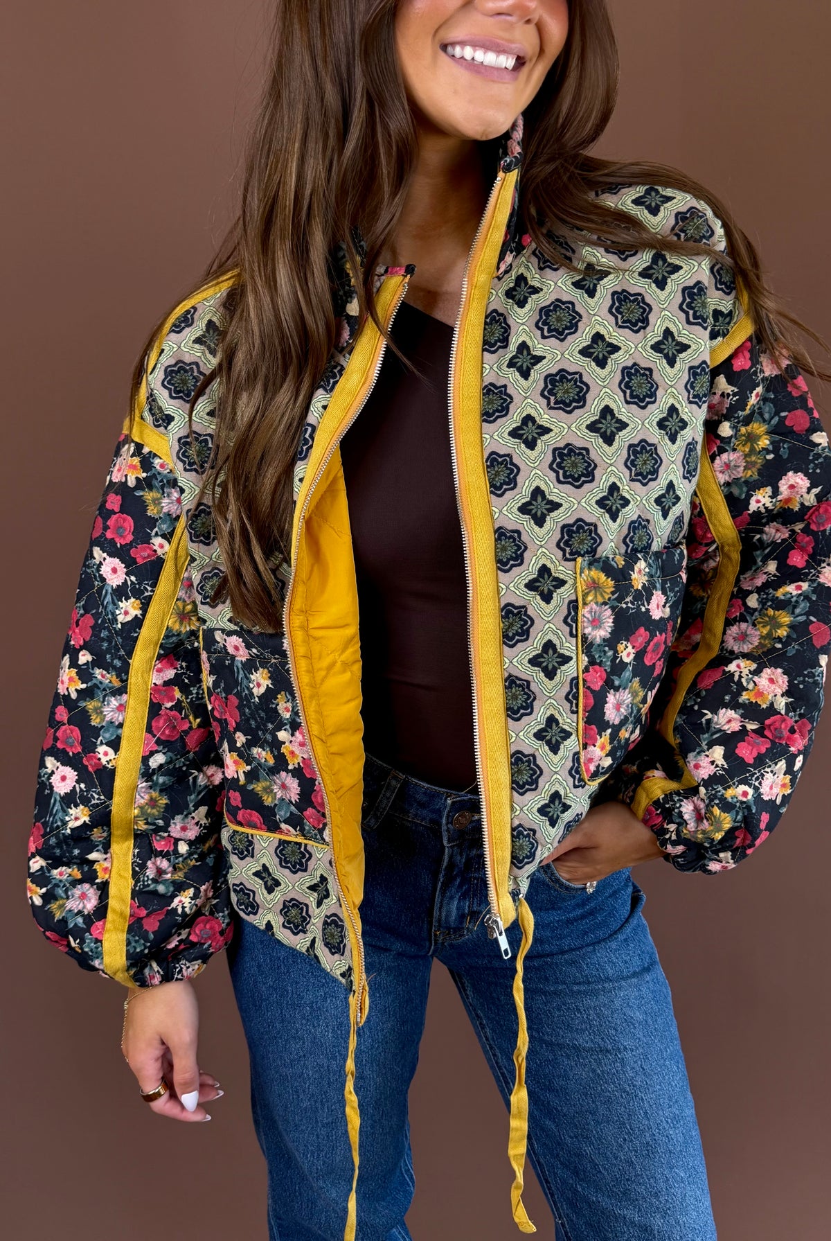 Marigold Garden women’s quilted jacket in a colorful floral print with a high neck, zip front, pockets, and adjustable cinch waist