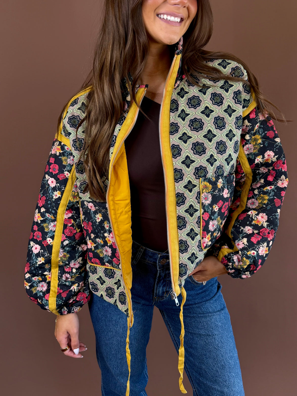 Marigold Garden women’s quilted jacket in a colorful floral print with a high neck, zip front, pockets, and adjustable cinch waist