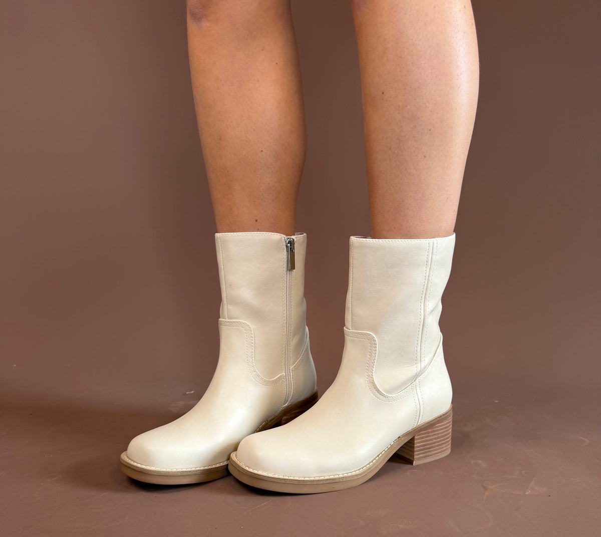 Ivory pleather mid-shaft boots with a side zipper and 2.8-inch stacked heel by MIA.