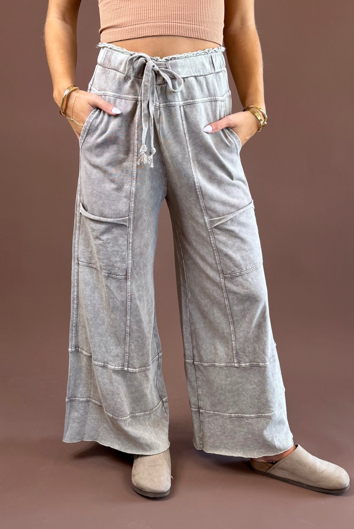 Mushroom Mist women’s mineral-wash pants with a relaxed wide-leg shape, elastic drawstring waist, roomy pockets, and raw-edge hems