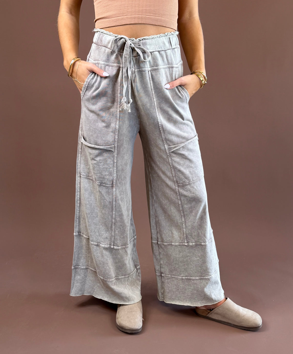 Mushroom Mist women’s mineral-wash pants with a relaxed wide-leg shape, elastic drawstring waist, roomy pockets, and raw-edge hems