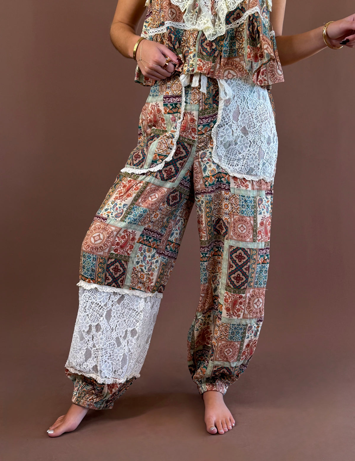 Model wearing floral patchwork balloon-leg joggers with lace panels and a drawstring waist, paired with the matching cami.