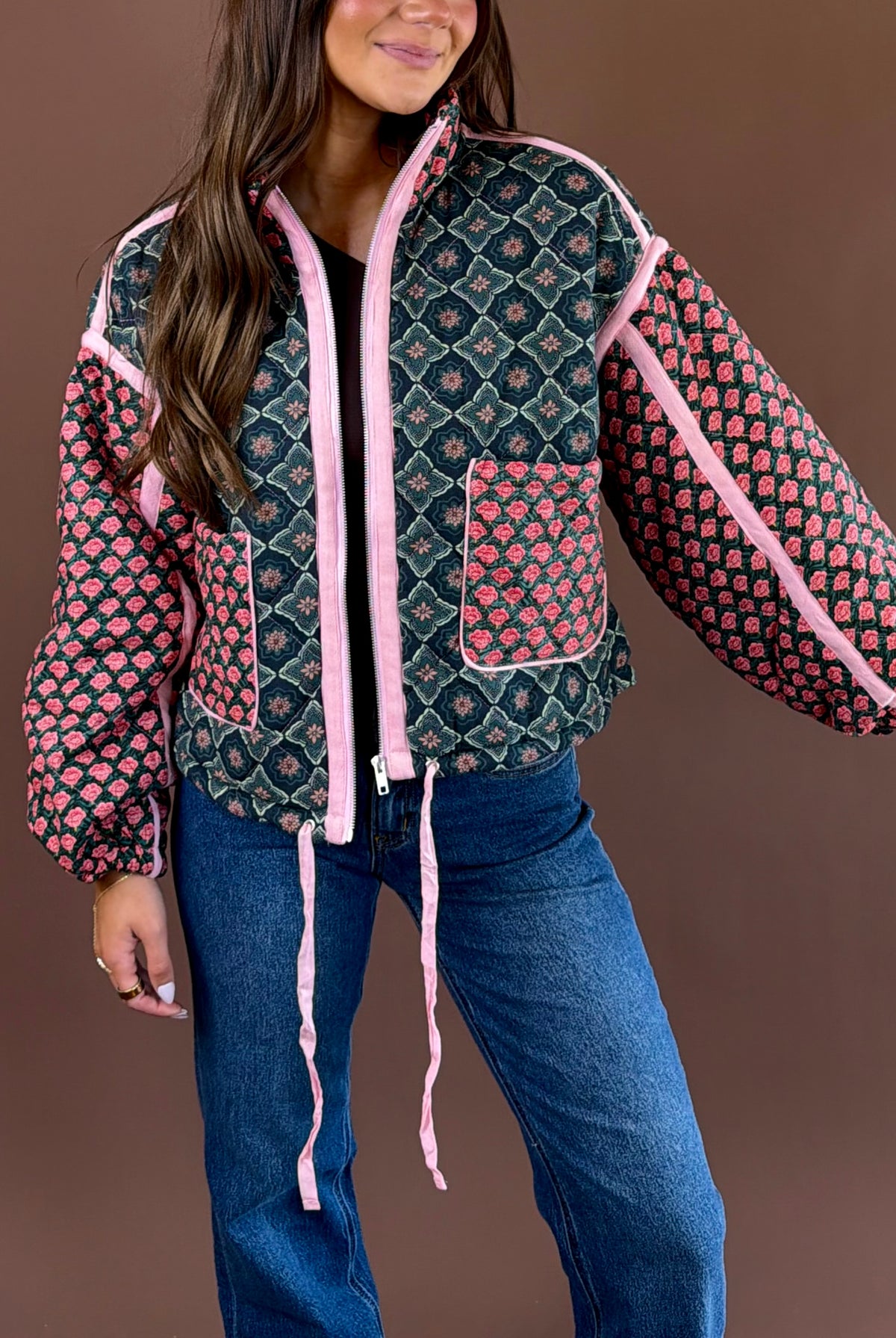 Rosy Daydream women’s quilted jacket in a rose multicolor floral print with a high neck, zip front, pockets, and adjustable cinch waist