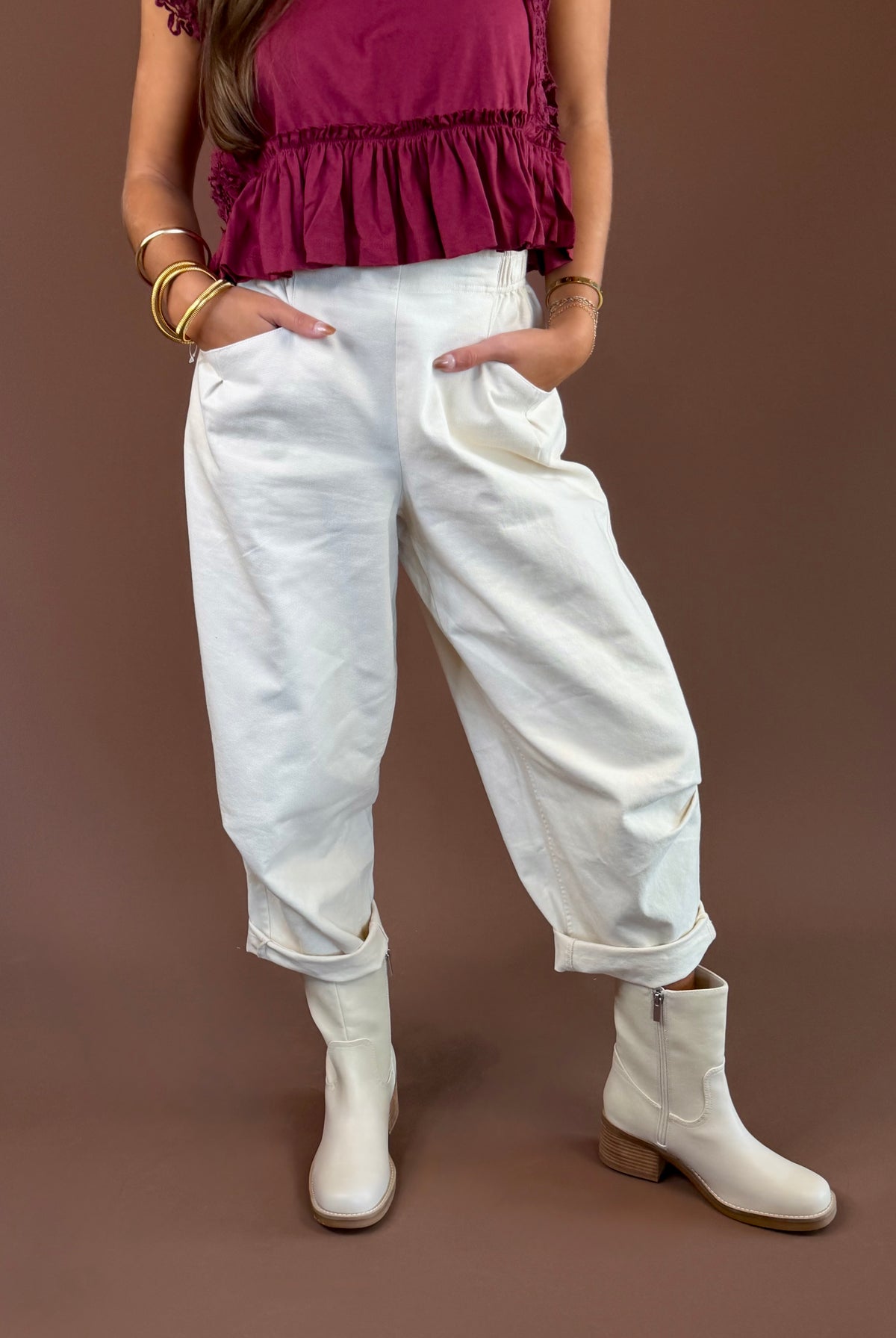Bone cream mineral-wash cotton pants with a high rise, pleated wide leg, elastic waist, and pockets.