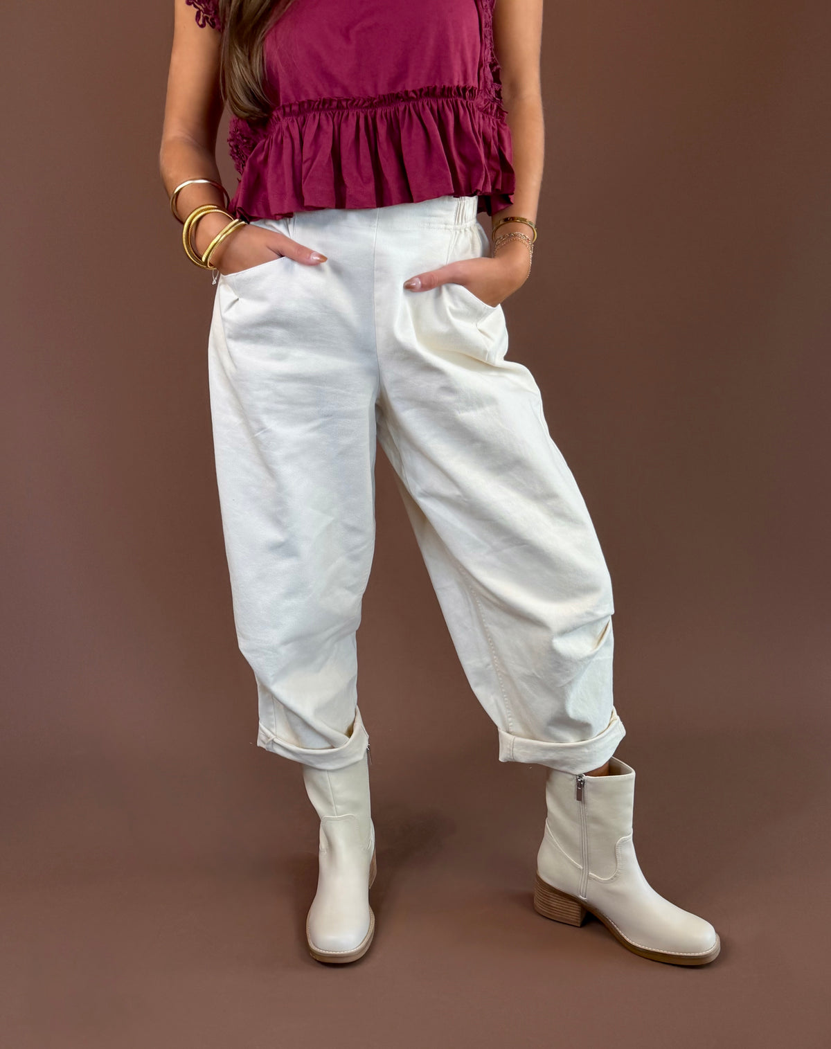Bone cream mineral-wash cotton pants with a high rise, pleated wide leg, elastic waist, and pockets.