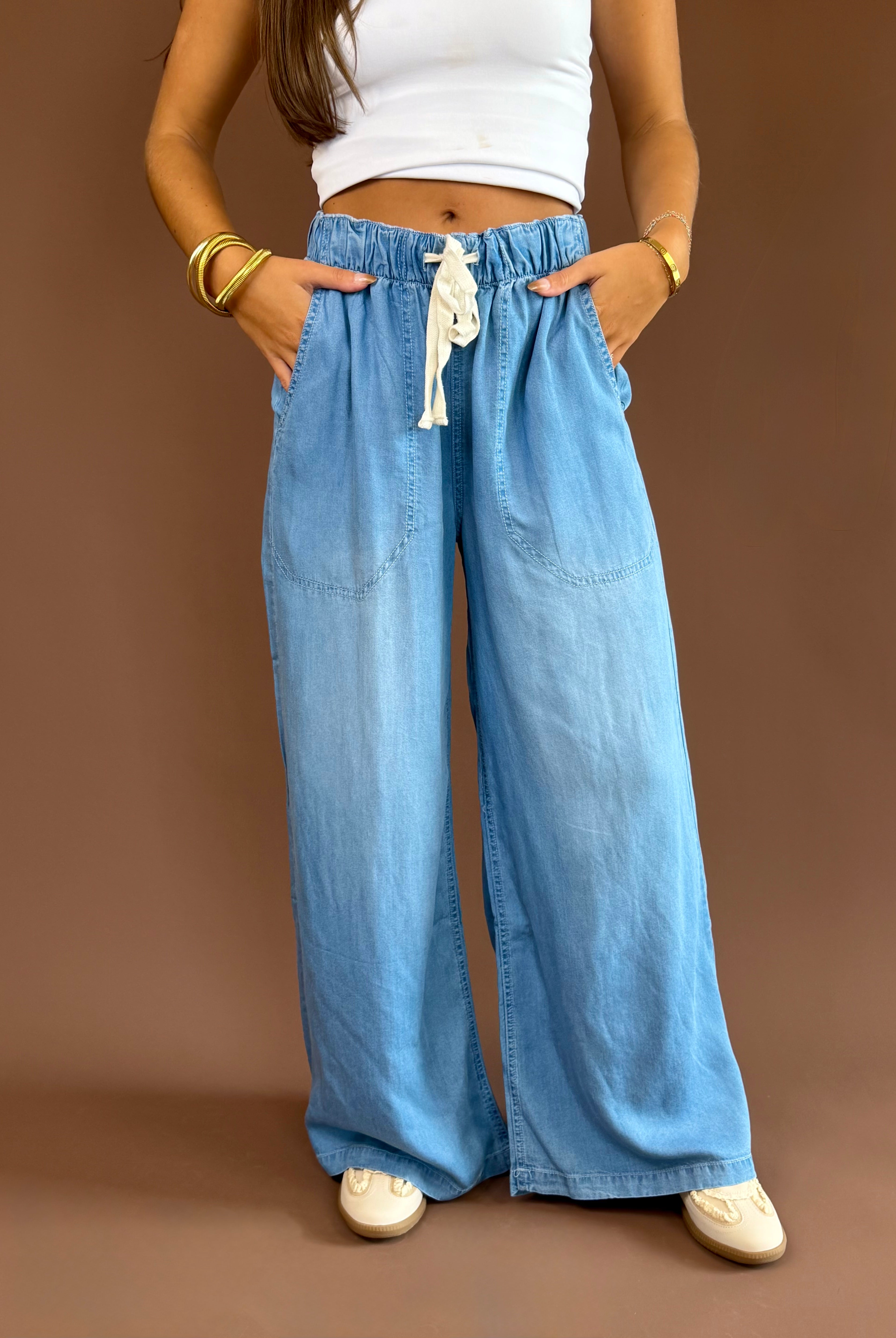 Soft denim pants with a high-rise elastic drawstring waist, wide legs, and side pockets.