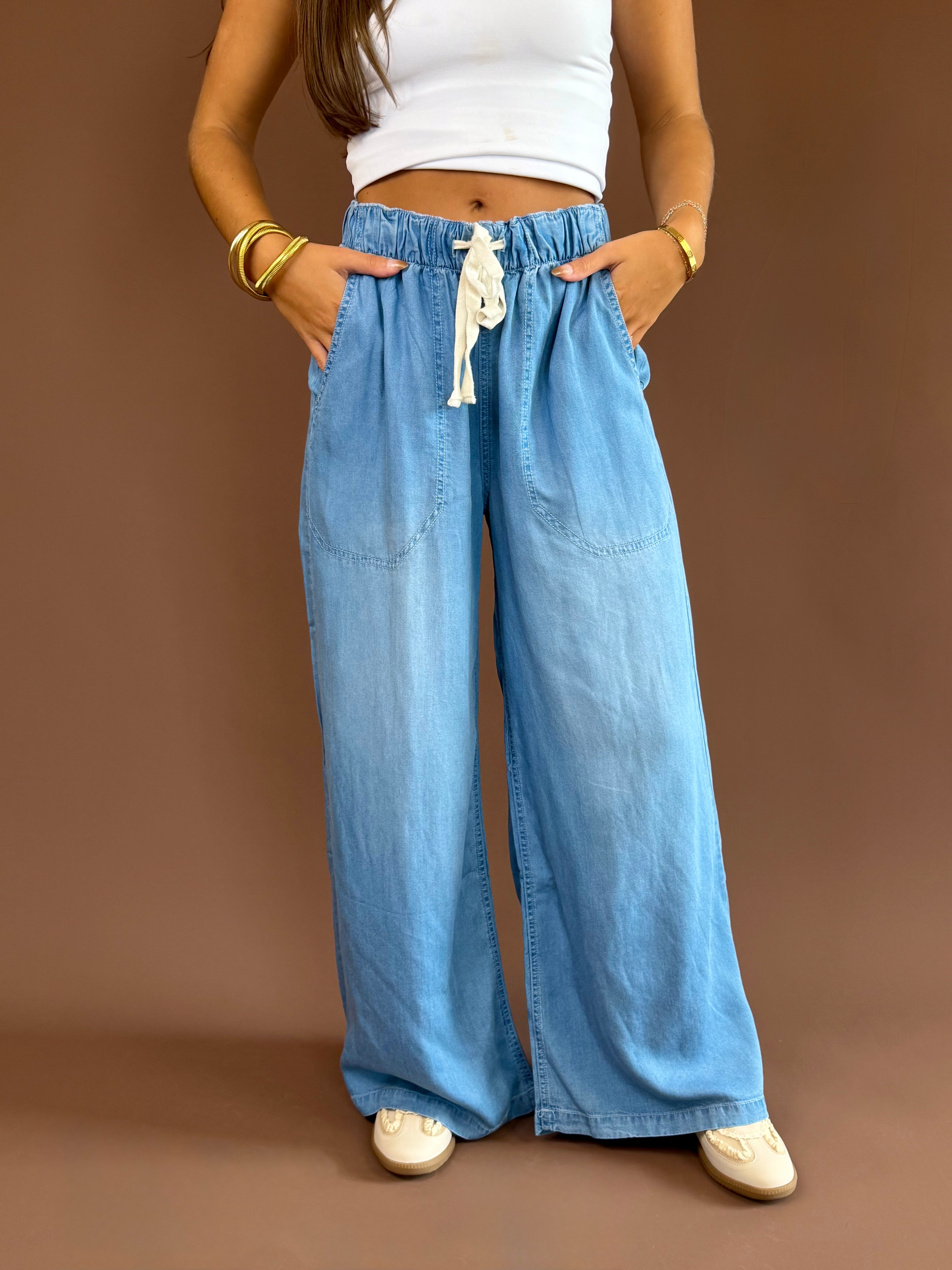 Soft denim pants with a high-rise elastic drawstring waist, wide legs, and side pockets.