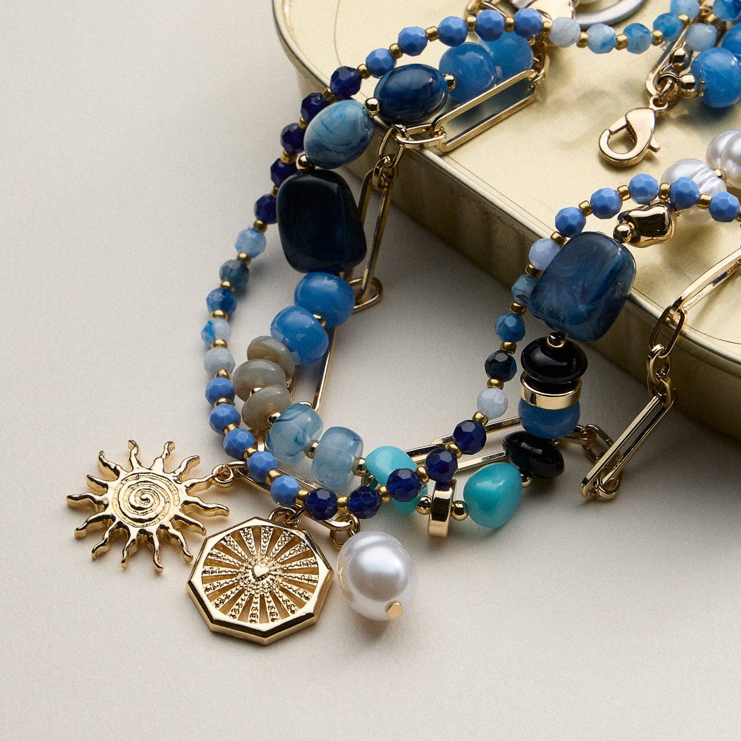 Multistrand beaded bracelet with gold charms on a light background, blue and gold necklace, accessory, summer necklace, gifts, necklaces 