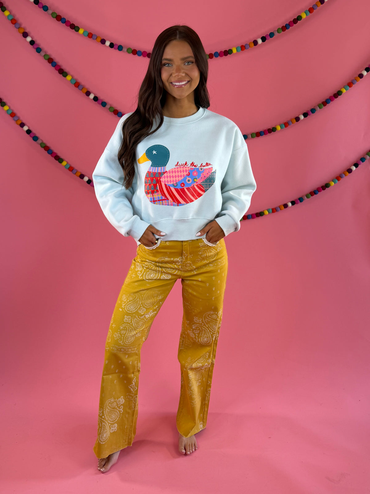 Full outfit with light blue duck sweatshirt: POPPY & PINE mustard yellow bandana paisley denim pants with frayed hems.