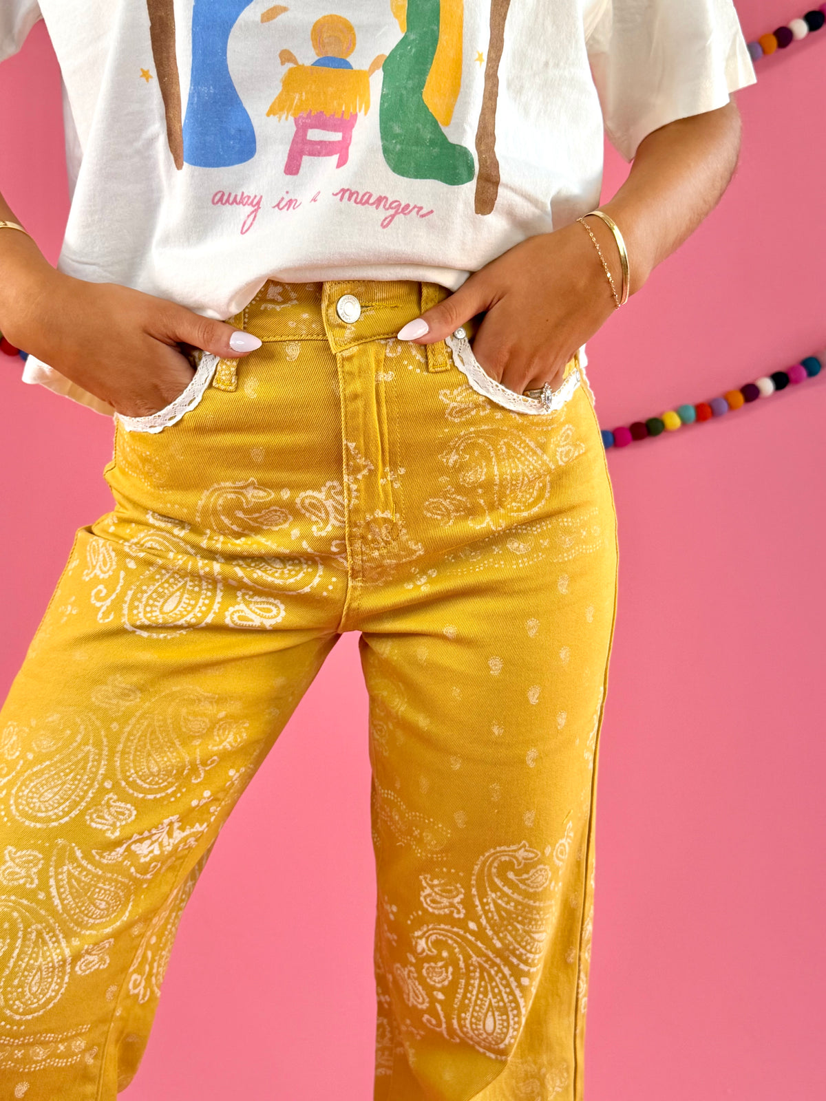 Waistband and front pocket detail: POPPY & PINE mustard yellow bandana paisley denim pants with frayed hems.
