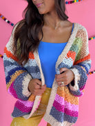 Open-front detail: Cream Rainbow Cardigan with multicolor stripes, an open front, and hip pockets.