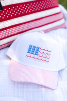 White baby hat with American flag design on a white blanket, pink and white, bows and stripes, beachy and bows, USA