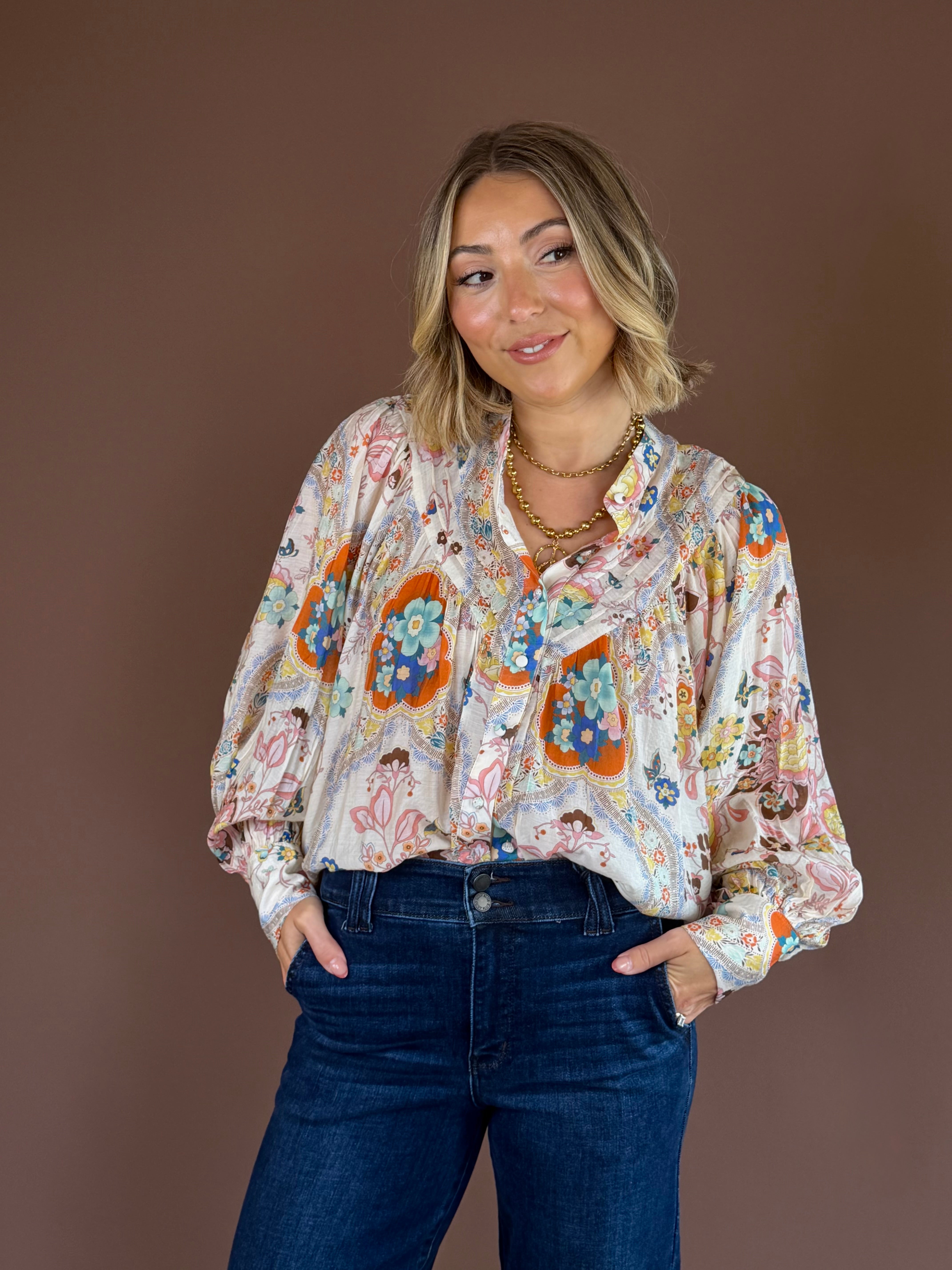 Apricot paisley button-down blouse with a pleated high neckline, long sleeves, and a relaxed fit.