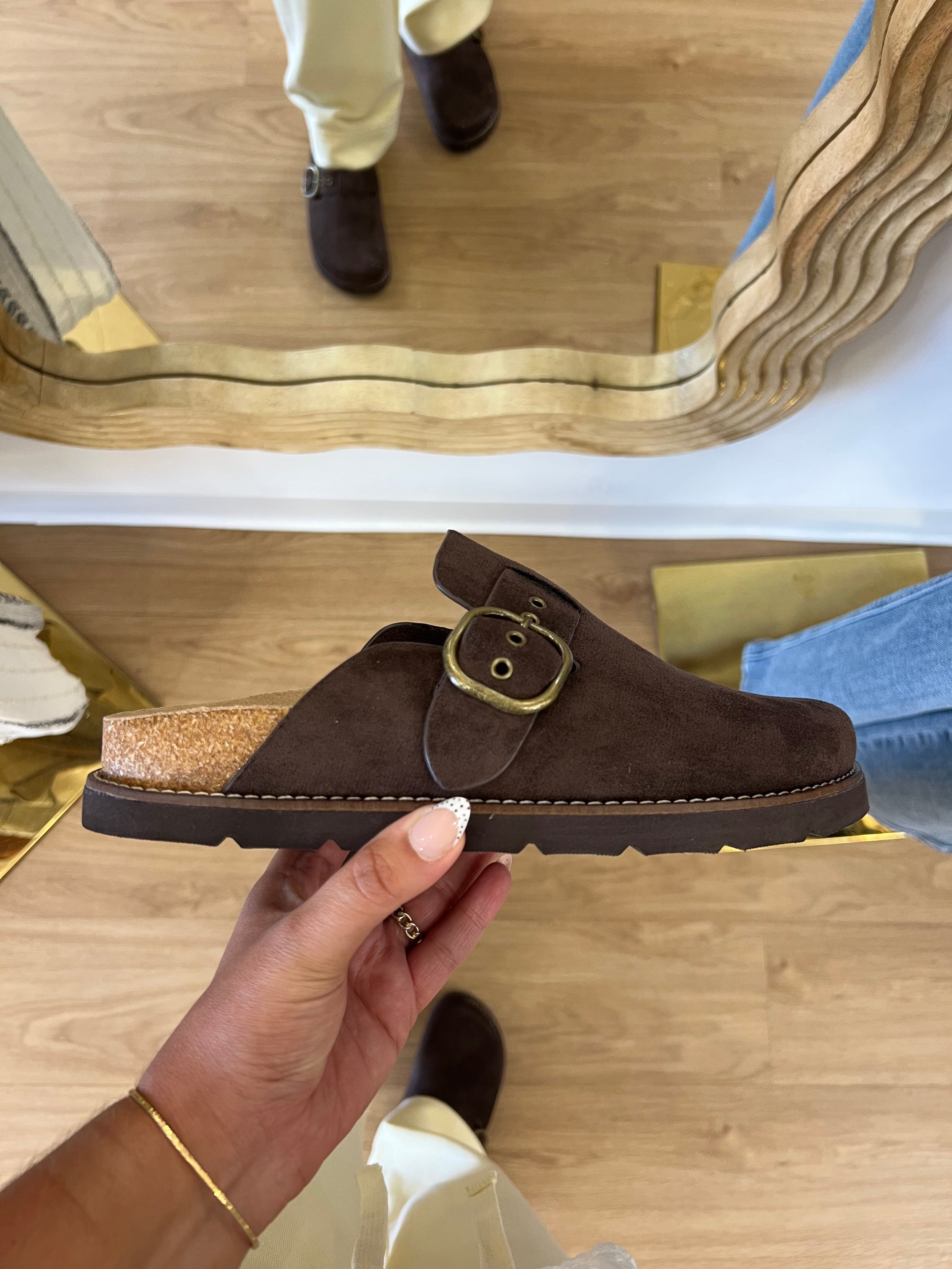 Corky’s Distracted women’s chocolate brown faux-suede clogs with a statement buckle, contoured footbed, and cushioned sole.