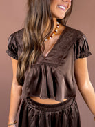 Espresso Hour women’s dark brown satin cropped blouse with tonal floral embroidery, cream lace trim, V-neckline, and cap sleeves