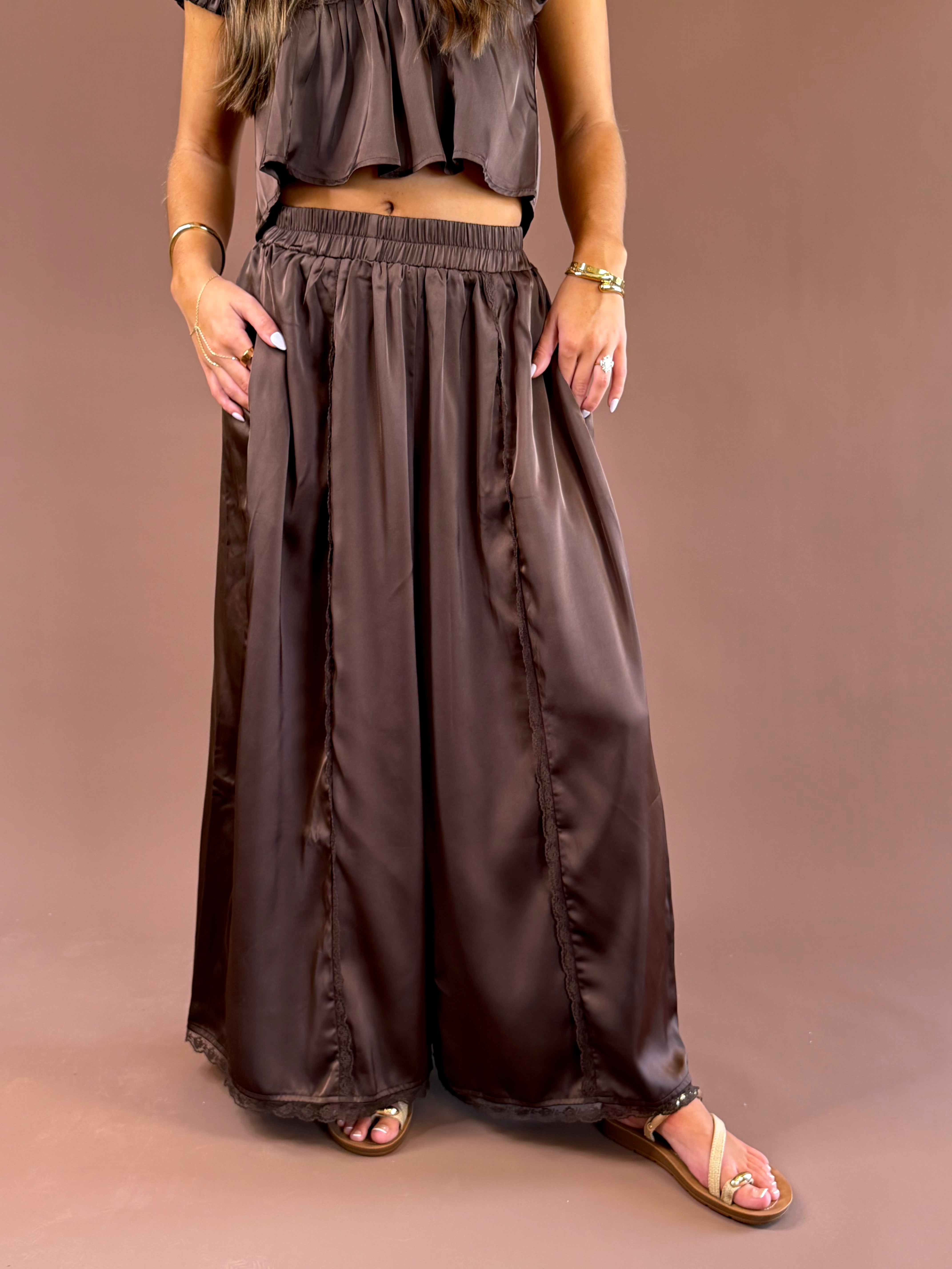 Espresso Hour women’s dark brown satin pull-on pants with a comfortable elastic waistband, subtle lace detailing, and flowy wide legs