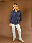 Navy blue pinstripe button-down blouse with long sleeves and an adjustable side-tie waist.