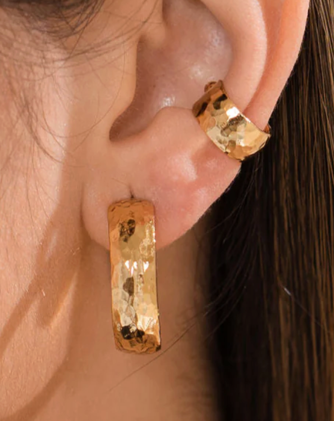 Close-up of a person wearing gold hoop earrings, hammered hoops, waterproof earrings, brenda grands
