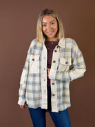 Model wearing the Golden Fields cream, yellow, and blue plaid shacket with contrasting textured panels, front pockets, and dark buttons over jeans.