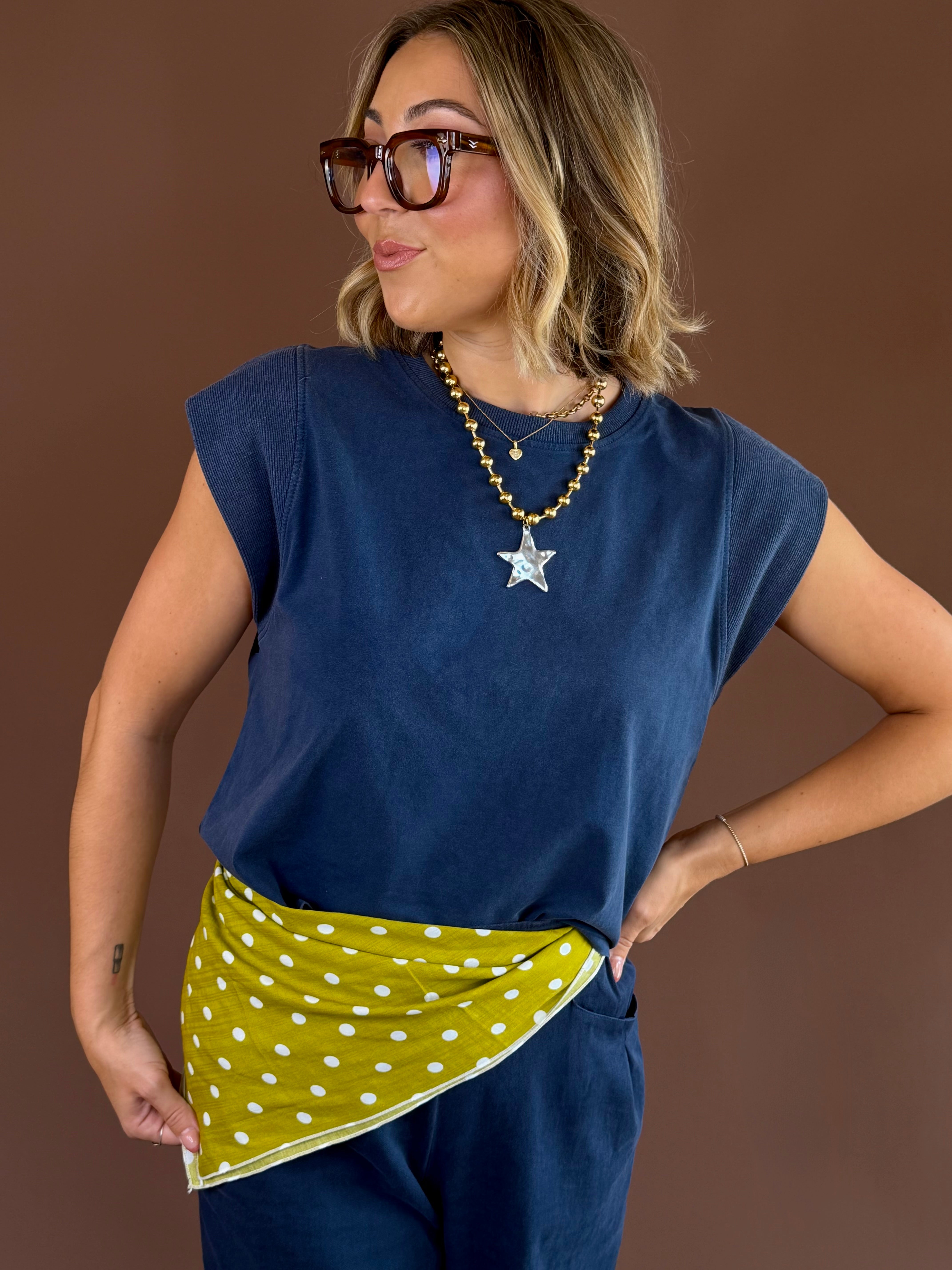 Indigo blue relaxed-fit top with cap sleeves, ribbed trim, and a high round neckline.