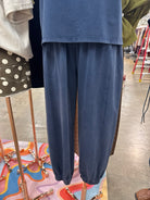 Indigo blue high-waisted jogger pants with an elastic waistband, relaxed fit, and cuffed ankles.
