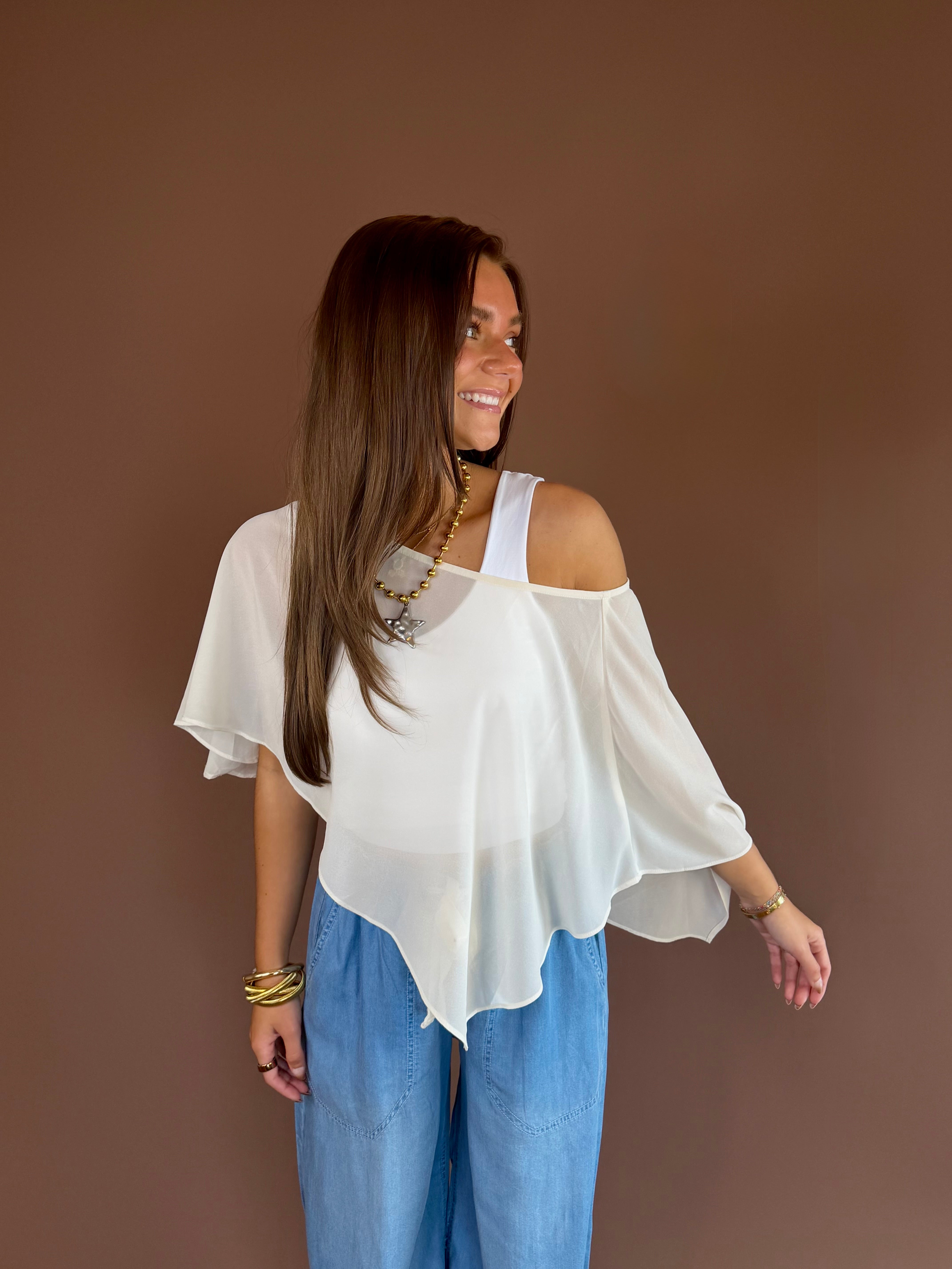 Cream ivory sheer poncho top with a cropped flowy silhouette and adjustable slouch neckline.