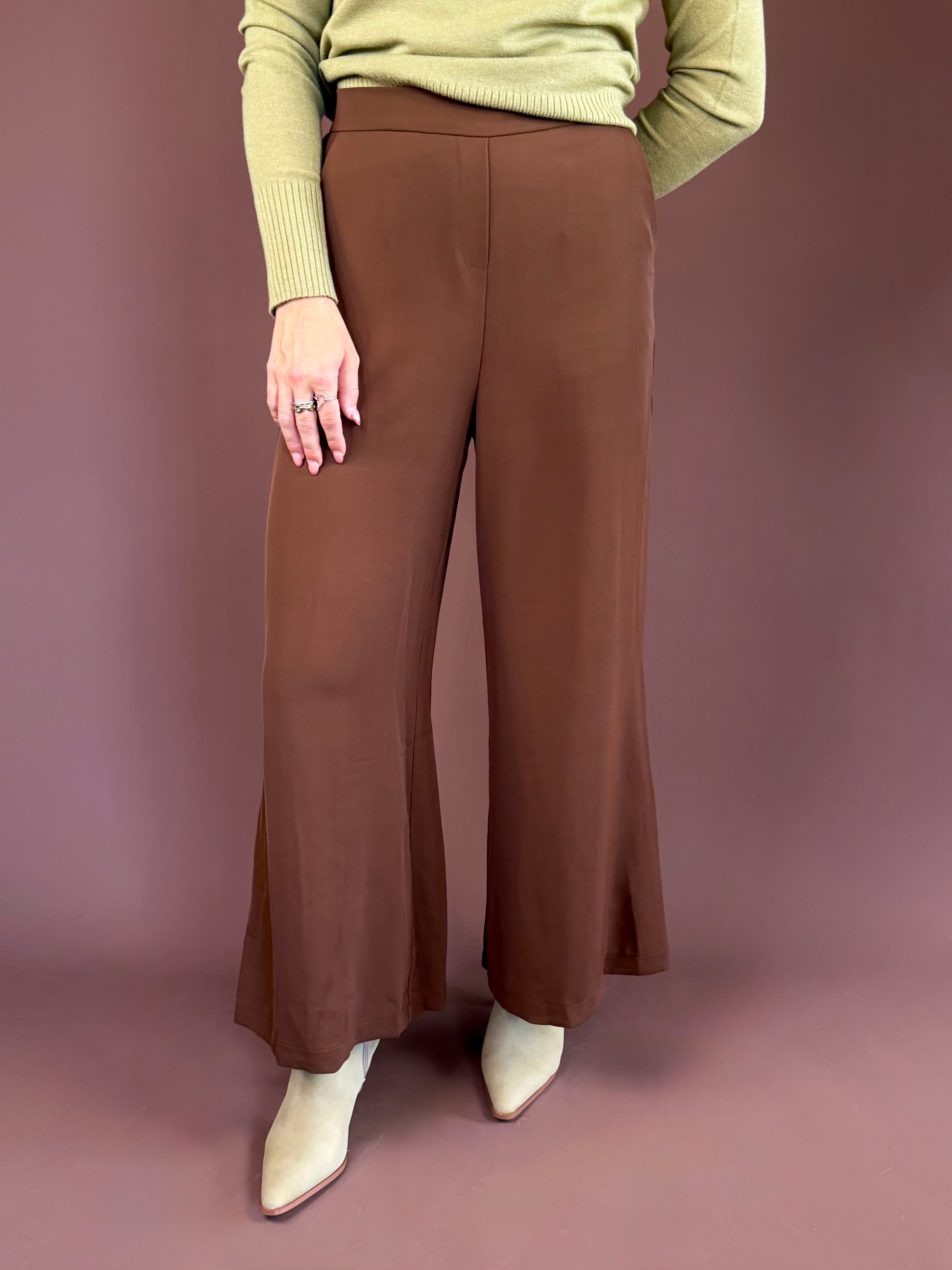 Chocolate brown high-waisted trouser pants with a wide leg, clasp-front closure, and side pockets.