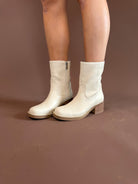 Ivory pleather mid-shaft boots with a side zipper and 2.8-inch stacked heel by MIA.
