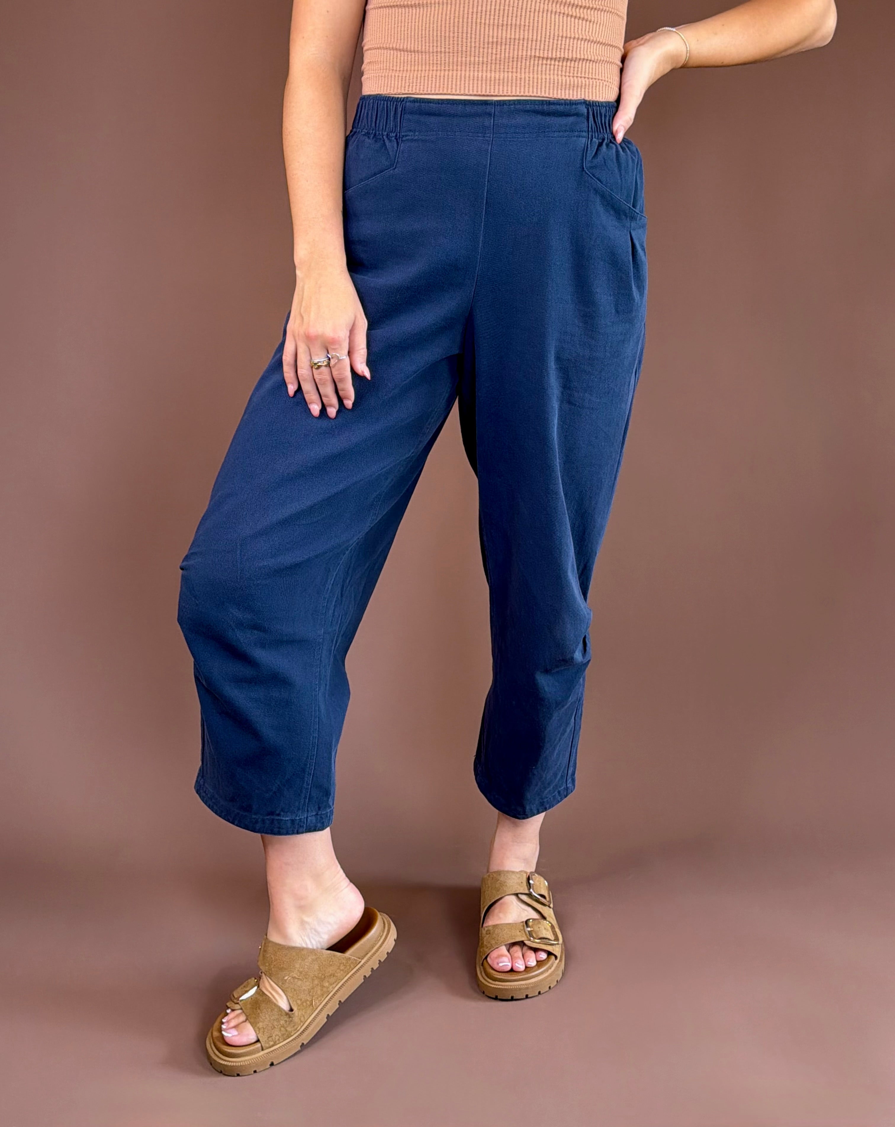 Midnight blue mineral-wash cotton pants with a high rise, pleated wide leg, elastic waist, and pockets.