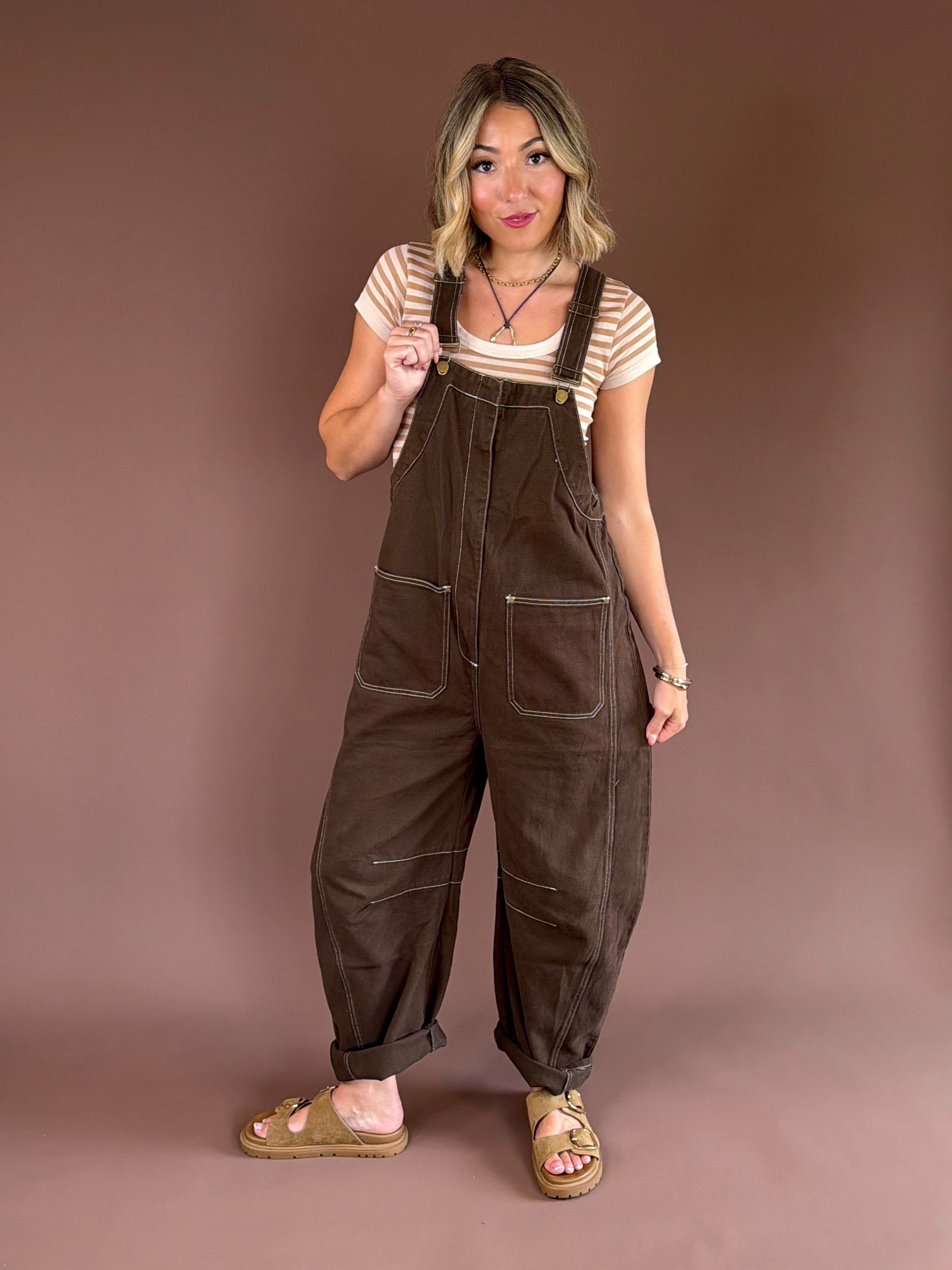 Women’s mocha brown denim overalls with adjustable straps, a relaxed wide barrel leg, patch pockets, and a straight bib front.