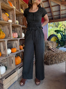 Model wearing dark olive gingham wide-leg pants with a flowy silhouette and an elastic drawstring waistband.