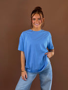 Model wearing a bright blue Glacier Bloom relaxed boyfriend T-shirt with short sleeves and a round neckline, styled with jeans.