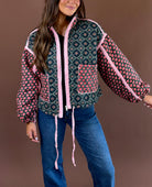 Rosy Daydream women’s quilted jacket in a rose multicolor floral print with a high neck, zip front, pockets, and adjustable cinch waist