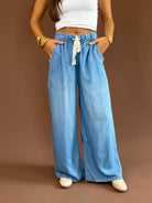 Soft denim pants with a high-rise elastic drawstring waist, wide legs, and side pockets.