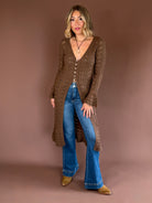 Women’s lightweight crochet-knit longline cardigan duster with a button front, flared sleeves, side slits, and midi length.