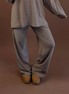 Model wearing cocoa striped wide leg fleece lounge pants with a matching long sleeve top and brown clogs.